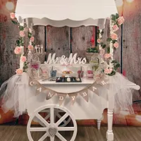 Weißer Candybar-Wagen mit Rosen und Süßigkeiten
