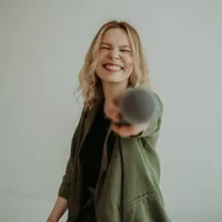 Vanessa lacht und streckt das Mikrofon zur Kamera