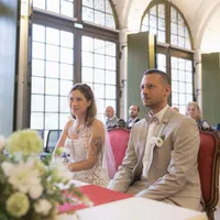 Brautpaar sitzt bei der Trauung in einem hellen Saal