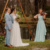 Violinistin spielt neben Brautpaar am Teich