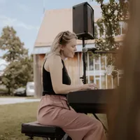 Vanessa singt am Keyboard bei einem Auftritt draußen