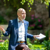 Trauredner mit Headset und Redemanuskript im Garten