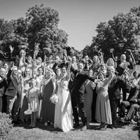 Jubelnde Hochzeitsgesellschaft mit Brautpaar, Gruppenfoto in Schwarz-Weiß