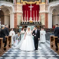 Brautpaar zieht aus der Kirche aus, Gäste stehen Spalier