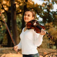 Violinistin mit Geige und Bogen im Herbstpark