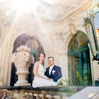 Brautpaar sitzt auf Balustrade im Gegenlicht