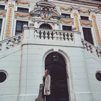 Vanessa mit Gitarrentasche vor einem historischen Portal