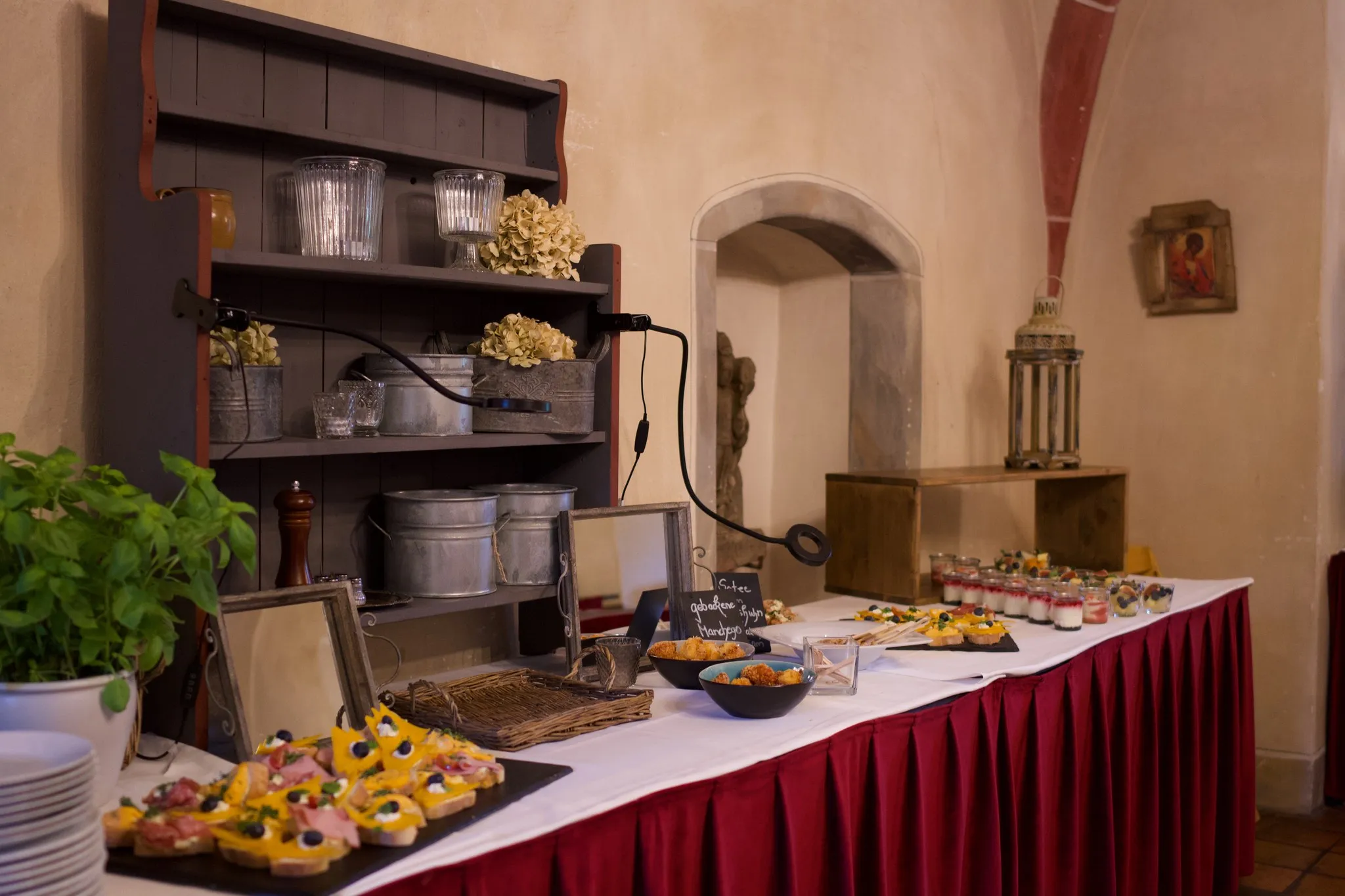 Buffet mit Fingerfood und Dessertgläsern im Gewölberaum