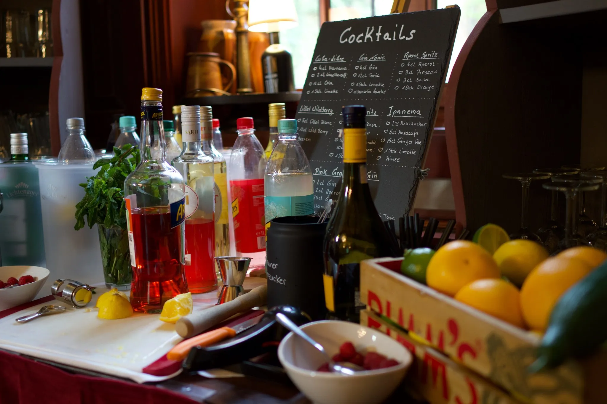 Cocktailbar im Schloss mit handgeschriebener Getränketafel und Zitrusfrüchten