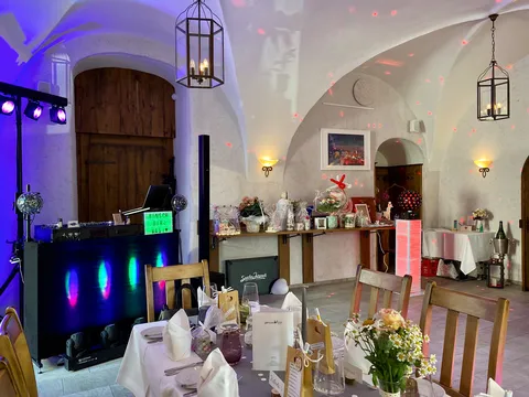 Gewölberaum mit DJ-Pult von Sascha Juranek und gedeckten Hochzeitstischen