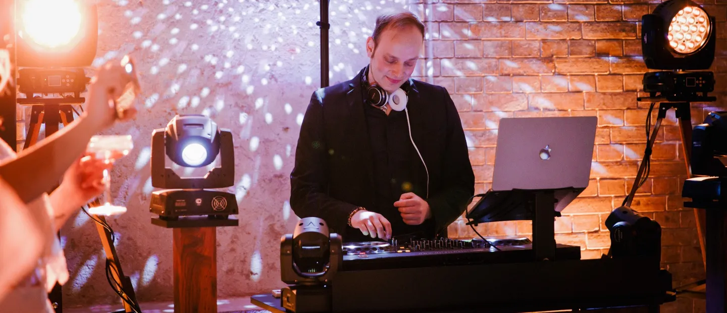 Brautpaar und Gäste auf der Tanzfläche, im Hintergrund DJ Sascha Juranek an seinem Pult