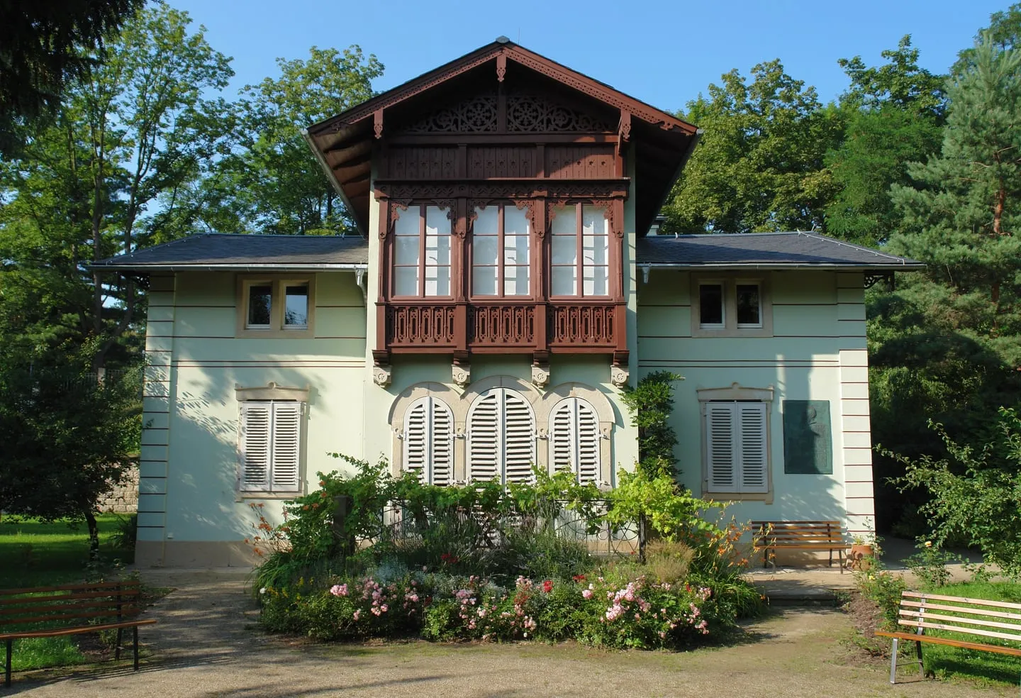 Kraszewski-Museum, eine hellgrüne Villa mit dunkelbraunem Erker, Fensterläden und einem blühenden Beet davor