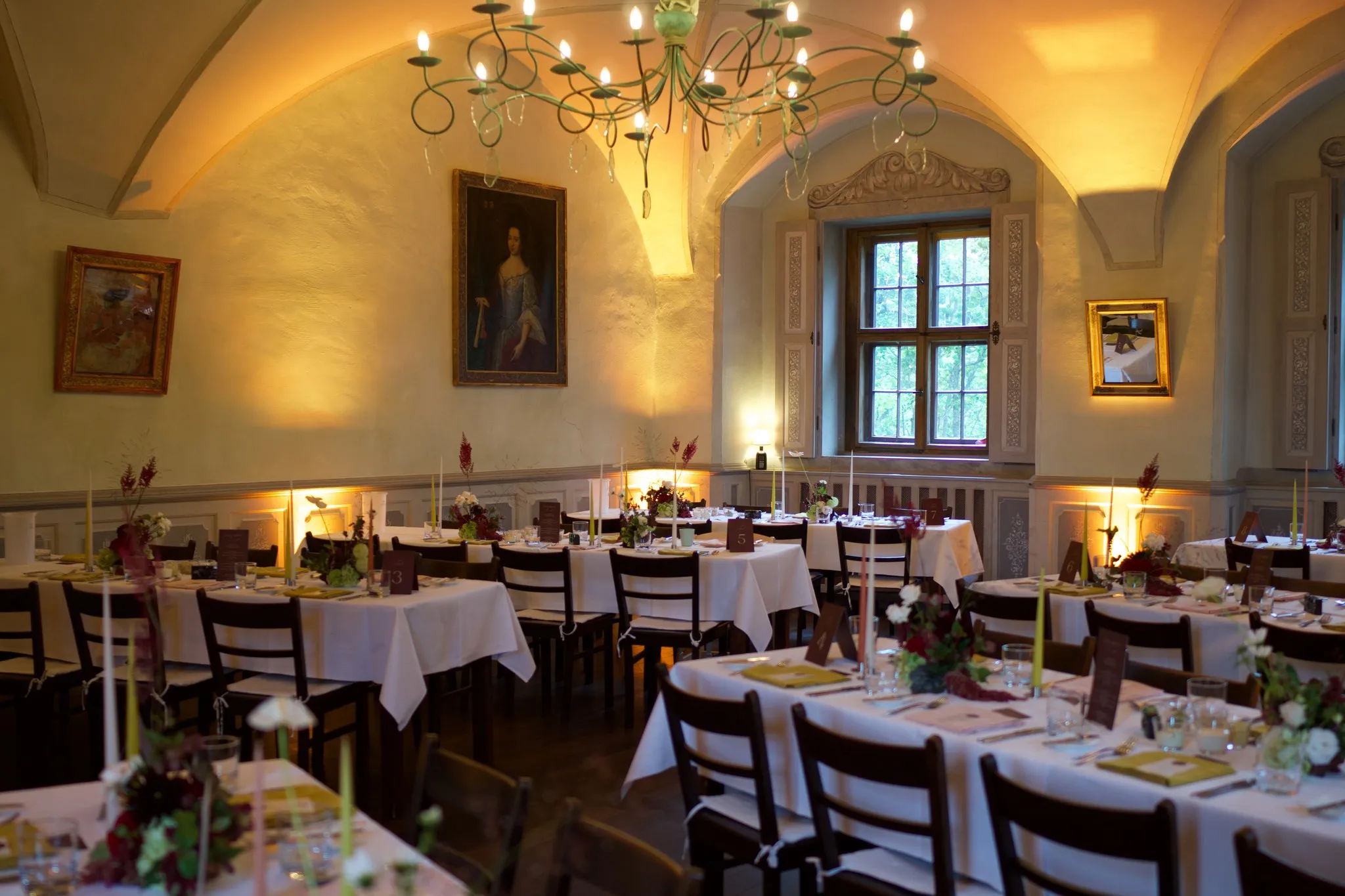 Schmiedeeiserner Kronleuchter und Damenporträt im Festsaal von Schloss Scharfenberg