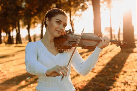 Violinistin Astrid Haferland spielt Geige im herbstlichen Park